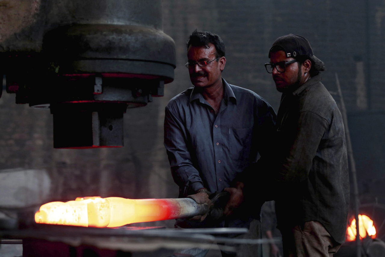 Dos hombres trabajan en una acería en la víspera del Día Internacional del Trabajador en Lahore, Pakistán. EFE/Rahat Dar