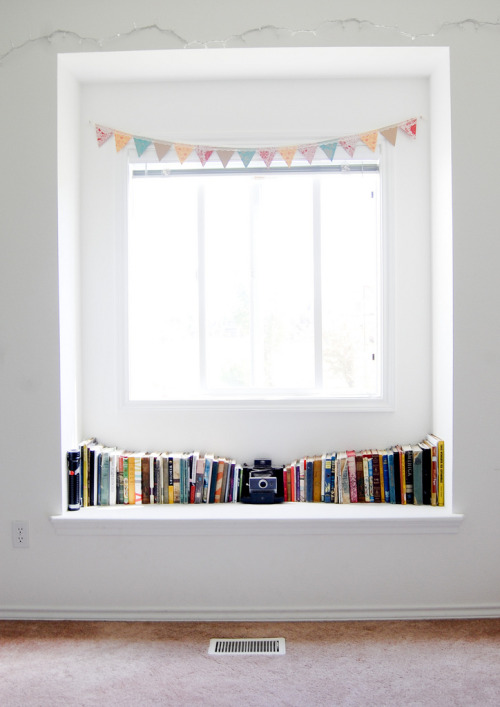 lovely window shelf with books, vintage camera and paper bunting (by karahaupt on flickr)
