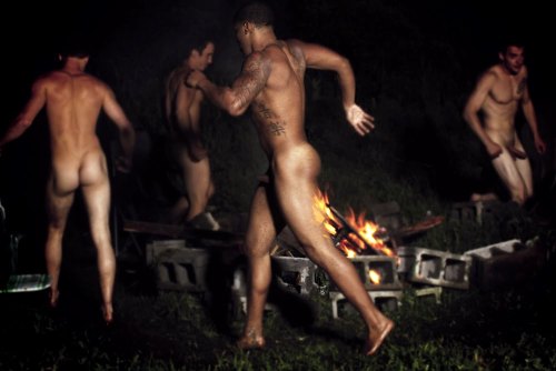 Nude male fire dancer